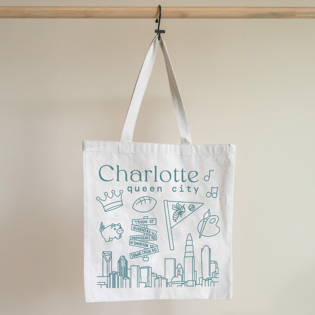 Tote bag with 'Charlotte queen city' text and graphics on a beige background