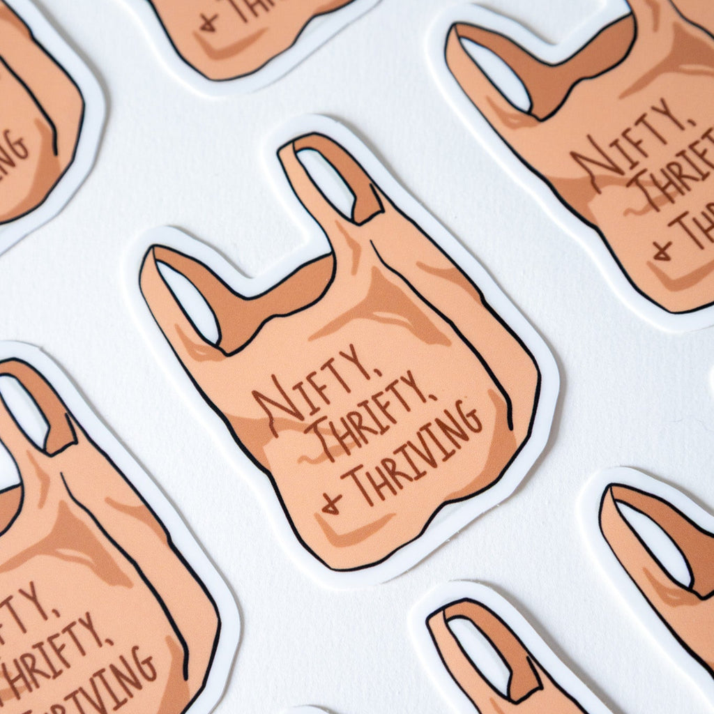 Sticker design of a reusable shopping bag with 'Nifty, Thrifty, Thriving' text on a white background.